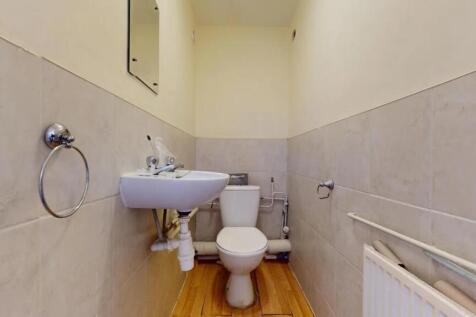 A compact and clean single toilet room featurin...