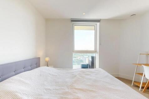 A bright and airy master bedroom featuring a co...