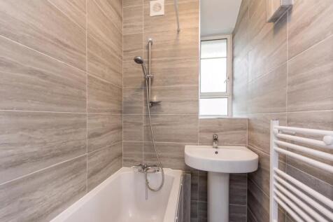 A modern bathroom suite featuring neutral-toned...