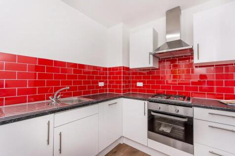 Bright and modern kitchen featuring vibrant red...
