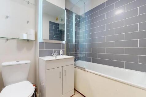 A modern bathroom suite featuring a clean white...