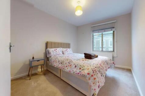 A bright and tidy double bedroom featuring a co...