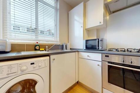 Bright and modern kitchen featuring white cabin...