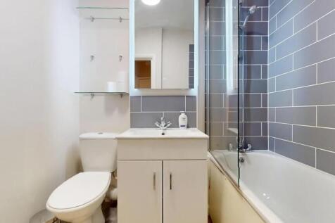 A modern bathroom suite featuring a clean white...