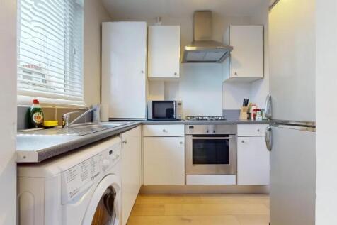 Bright and modern kitchen featuring sleek white...