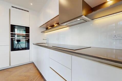 A sleek modern kitchen featuring clean white ca...