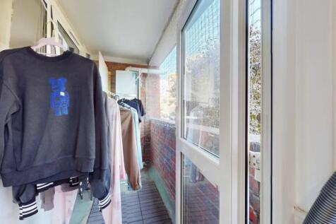 A bright enclosed balcony area with ample natur...