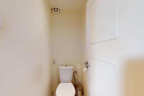 Compact and clean single toilet room with a sim...
