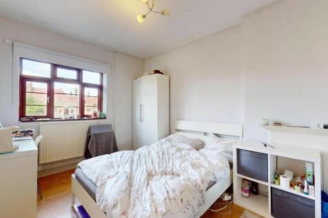 A bright double bedroom featuring a comfortable...