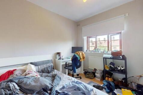 A bright double bedroom featuring a comfortable...