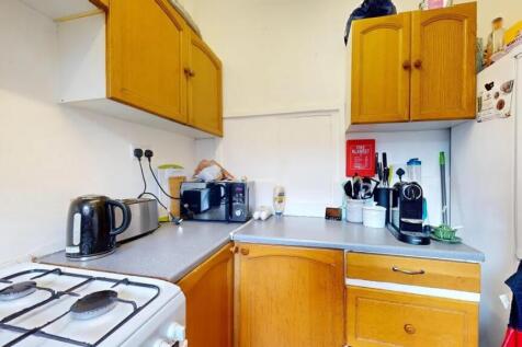 Compact kitchen featuring wooden cabinetry and ...