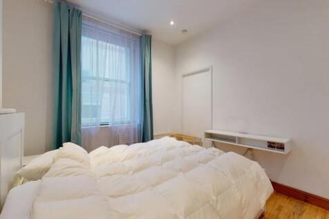 A bright and clean master bedroom featuring a l...