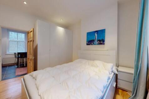 A bright double bedroom featuring a comfortable...