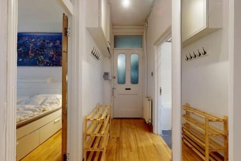 Bright and tidy hallway featuring polished wood...