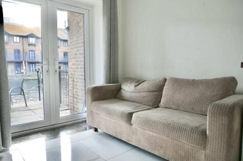 A bright and tidy living room featuring a comfo...