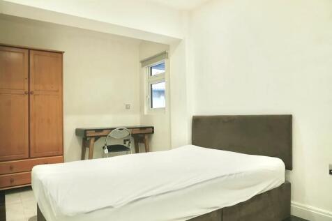 A neat double bedroom featuring a comfortable b...