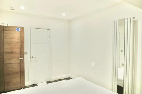 A clean and modern double bedroom featuring bri...