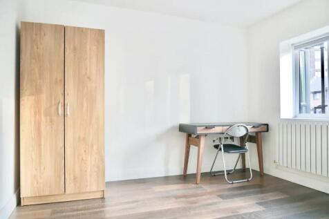 Bright and tidy room featuring a wooden wardrob...