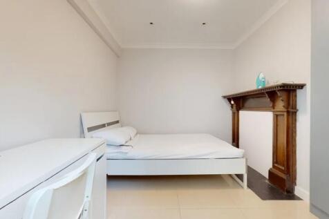 A clean and minimalist bedroom featuring a whit...