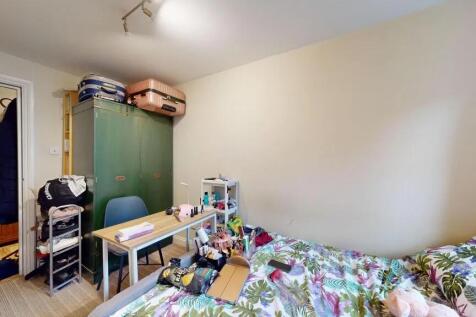 A cozy bedroom featuring a bed with vibrant bot...