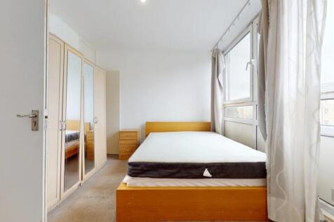 A bright double bedroom featuring a large windo...