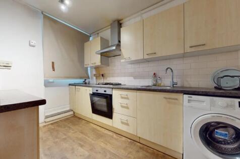 A modern kitchen featuring light wood cabinetry...