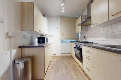 A neat and functional kitchen featuring light w...
