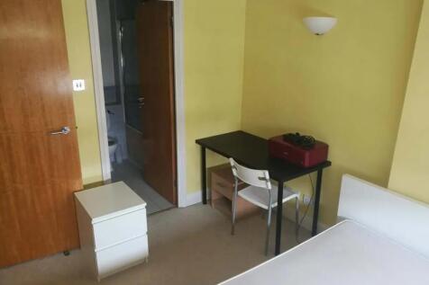 Cozy single bedroom featuring a neat study desk...