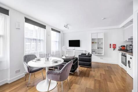 Bright and modern living room featuring large w...