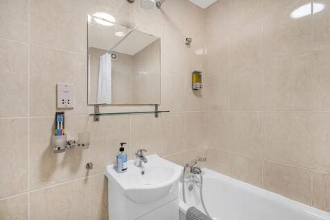 Bright and clean bathroom suite featuring a mod...
