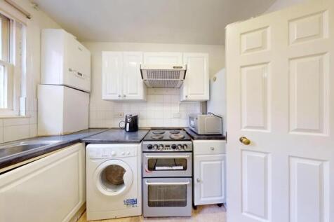 Bright and functional kitchen featuring white c...