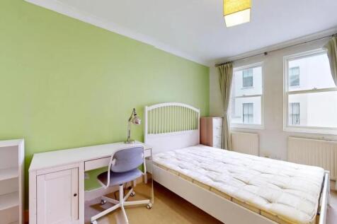 A bright single bedroom featuring a comfortable...