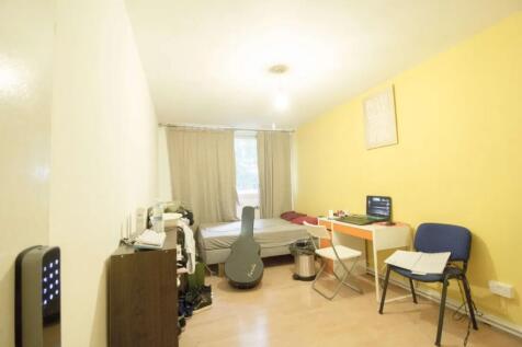 A modest, functional student bedroom with a sin...