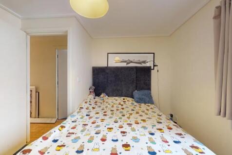 A cozy double bedroom featuring a charming patt...