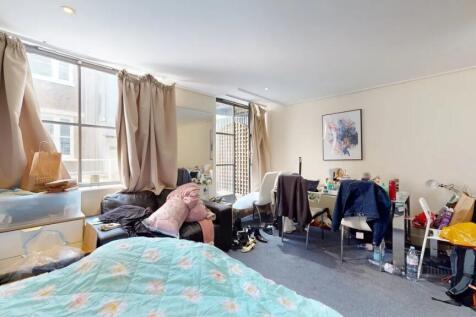 Bright double bedroom featuring a cozy bed with...