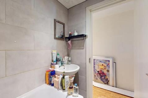 A neat and modern bathroom featuring a white si...