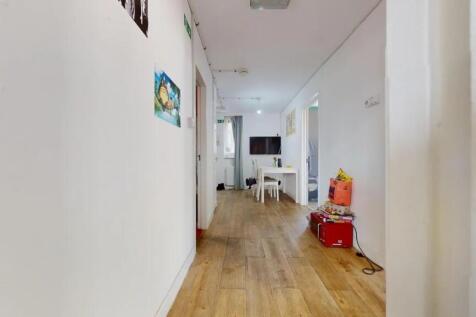 A bright and clean hallway with light wood floo...