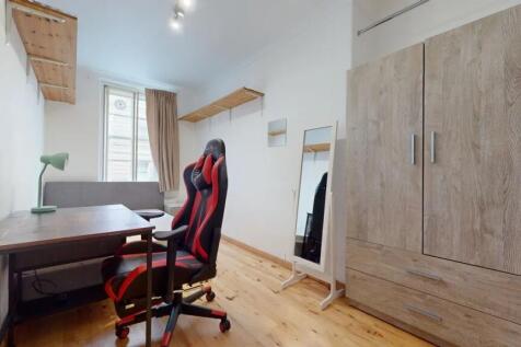 A bright and tidy bedroom featuring a comfortab...