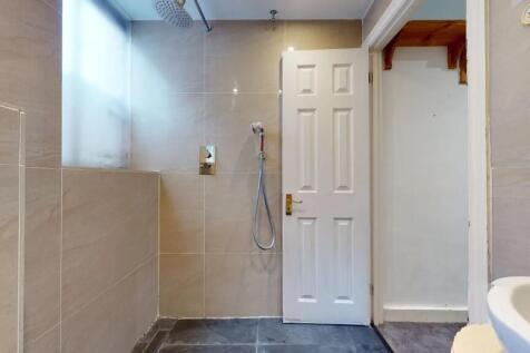 A modern bathroom featuring beige tiled walls a...