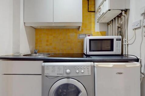 Compact kitchen area featuring essential applia...