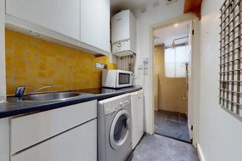 Compact kitchen space featuring modern white ca...