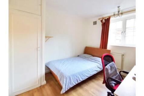 A bright double bedroom featuring a comfortable...