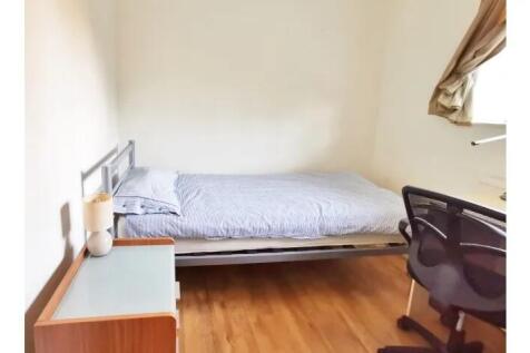 A neat single bedroom featuring a comfortable b...