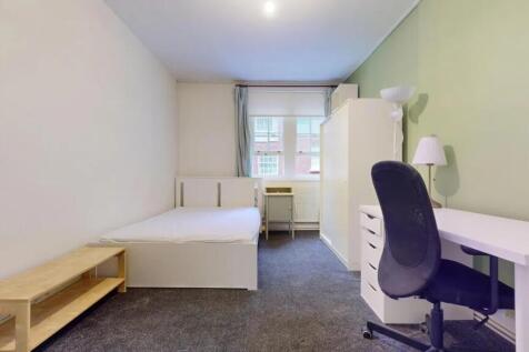 A neat and well-lit single bedroom featuring a ...