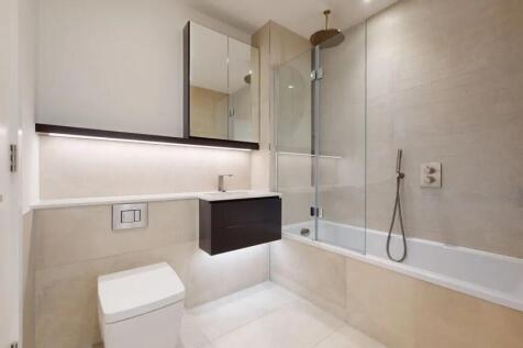 A sleek, modern bathroom suite featuring a spac...