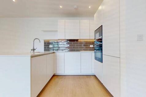 Modern kitchen featuring sleek white cabinets, ...