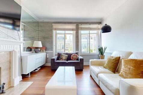 A bright and contemporary living room featuring...