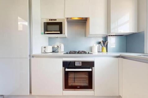 Bright and modern kitchen featuring sleek white...