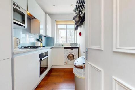 A sleek and modern kitchen featuring white cabi...