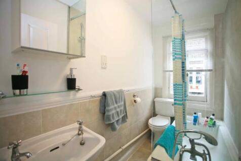 A bright and clean bathroom suite featuring a c...